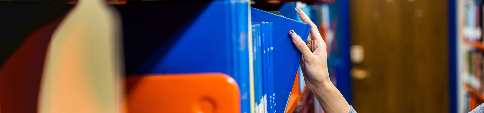 Student taking book from the shelf